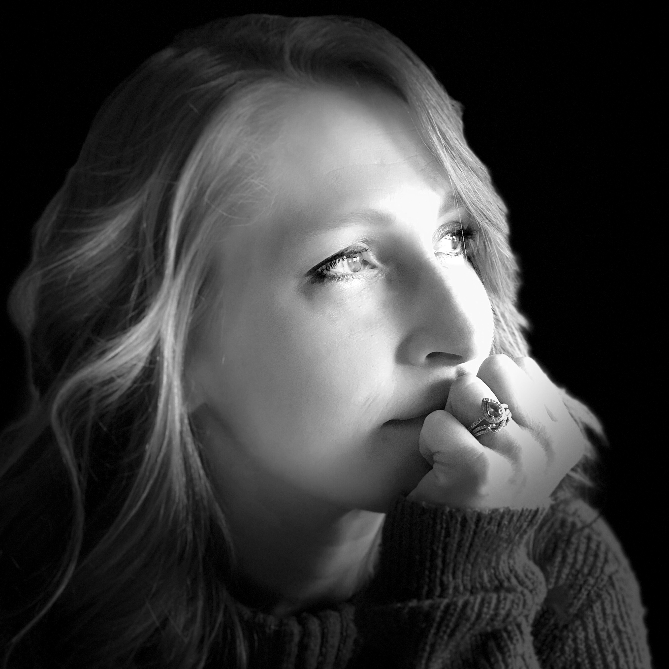 A black and white image of a redhead female looking pensively to the viewer's right